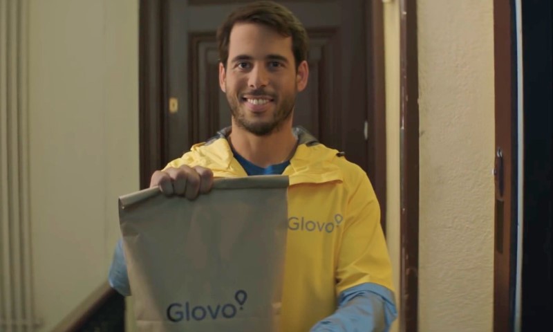 Glovo dostavljač stoji na vratima stana